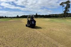 Core-sweeping-the-large-practice-green-on-The-Pines-golf-course
